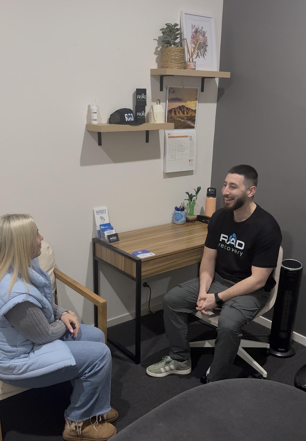 Adam Gaudiano discussing treatment with a seated client at RAD Recovery in Lilydale.
